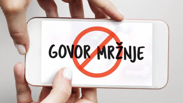 Telefon u rukama prikazuje natpis „Govor mržnje“ precrtan narandžastim znakom zabrane.
