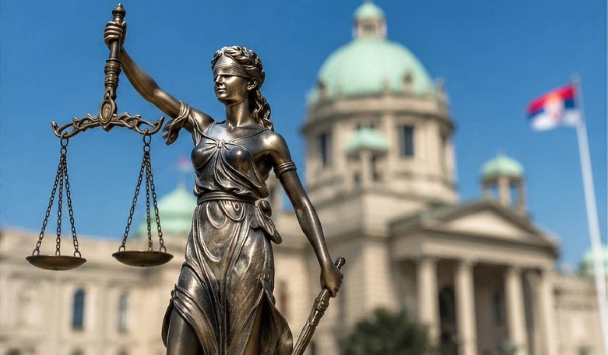 Statua pravde sa vagom ispred zgrade državne institucije i zastave Srbije.